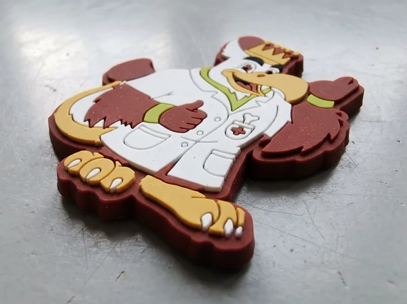 Calamite 3D personalizzate in PVC su più livelli, con una mascotte a rilievo accanto a una calamita 2D